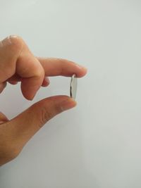 Close-up of hand holding hands over white background