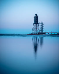 View of tower on sea against clear sky