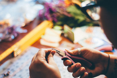 High angle view of woman making necklace