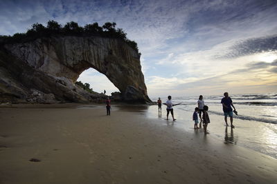 People on beach against sky