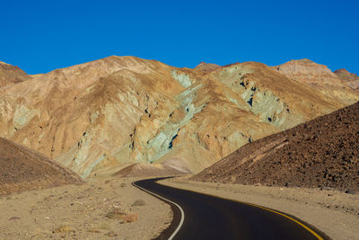 Scenic view of desert against clear blue sky