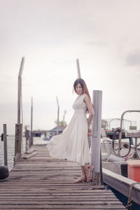 Woman standing on wood against sky