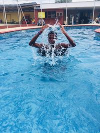 Man splashing water in swimming pool