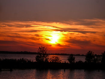 Scenic view of lake against romantic sky at sunset