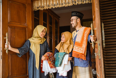 Happy family standing at door at home