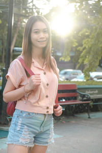 Portrait of young woman standing in city