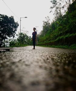 Rear view of man walking on road