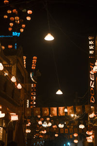 Low angle view of illuminated pendant lights hanging in building at night