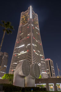 Low angle view of illuminated buildings against sky at night