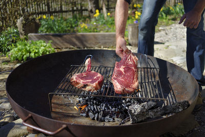 High angle view of man preparing food on barbecue grill