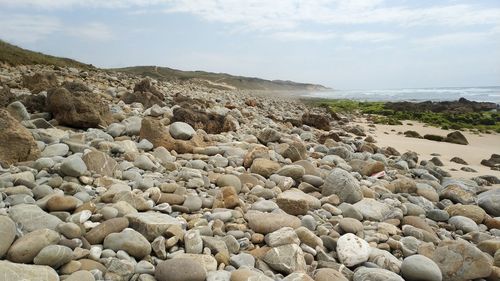 Rocks on beach against sky