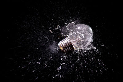 Close-up of light bulb over black background