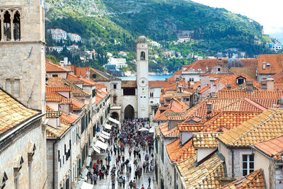 High angle view of people walking on street amidst buildings in city