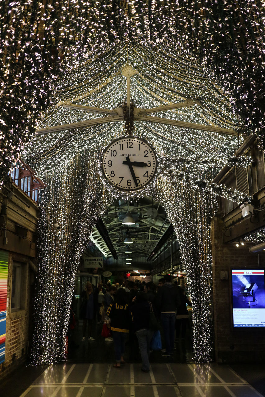 PEOPLE IN ILLUMINATED CLOCK ON CEILING