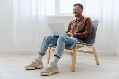 Low section of woman using laptop at home