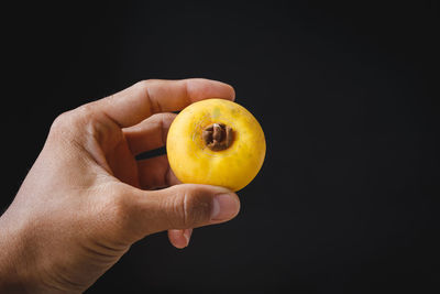 Midsection of person holding apple against black background