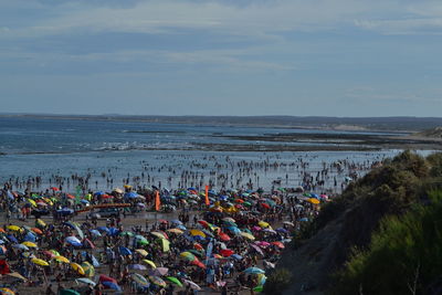 Group of people on beach against sky