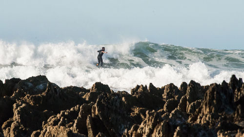 Man surfing in sea against sky