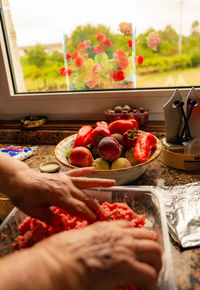 Cropped hand of woman holding food on table