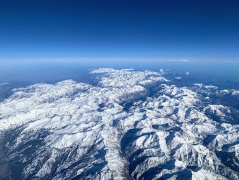 Scenic view of snowcapped mountains against blue sky