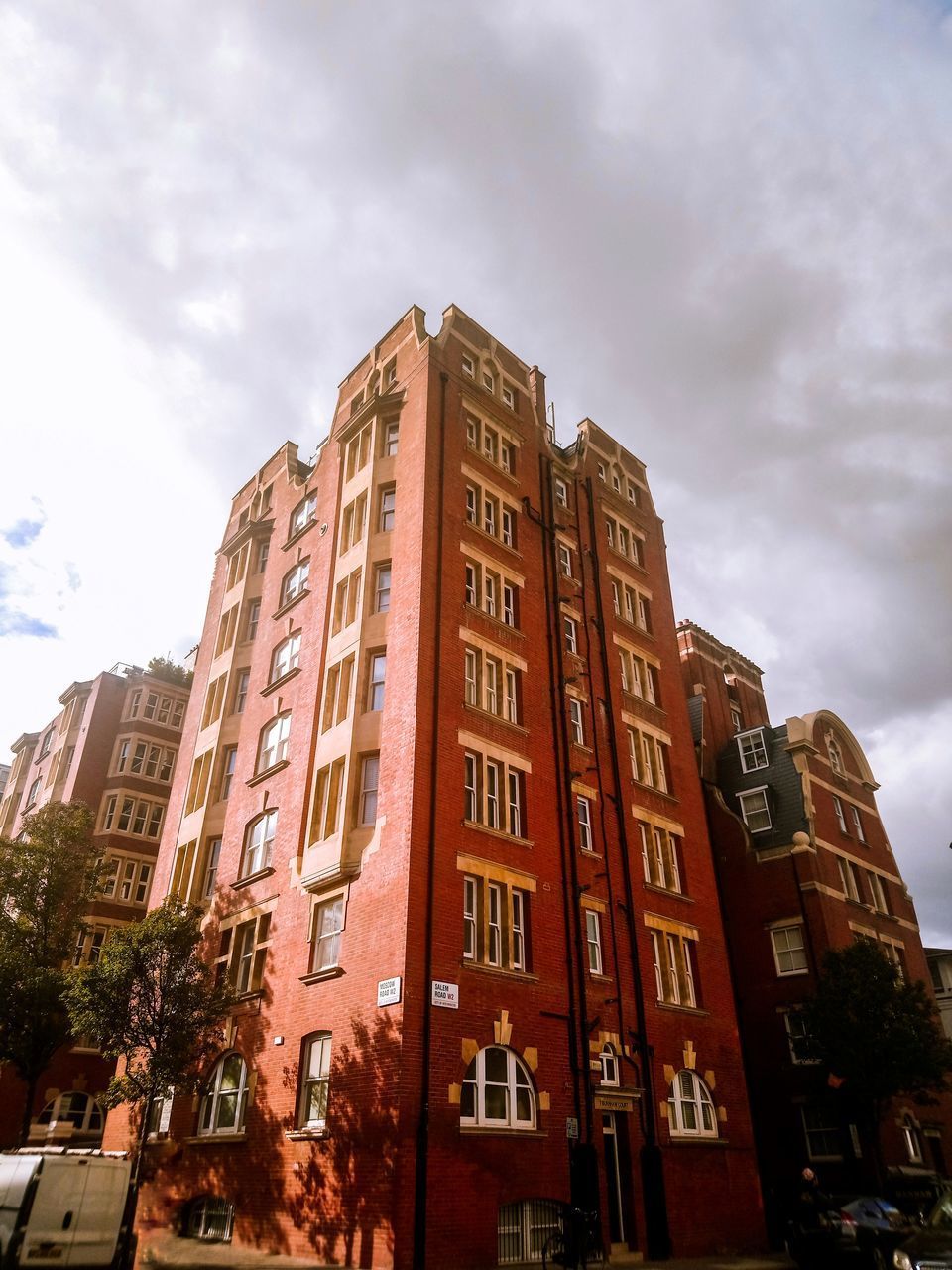 LOW ANGLE VIEW OF BUILDINGS BY STREET AGAINST SKY