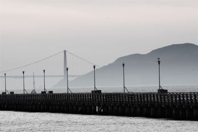 Bridge over sea against clear sky