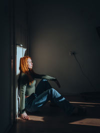 Side view of woman sitting on stage