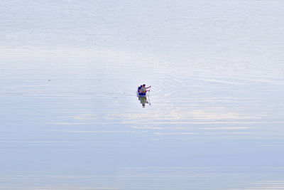 Mid distance view of people boating in lake