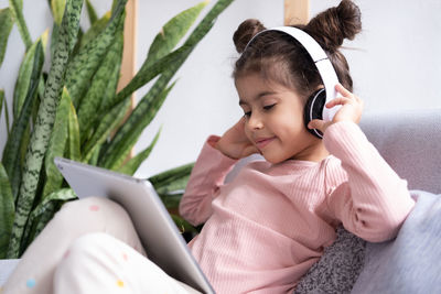 Cute girl using digital tablet at home