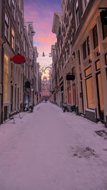 Street amidst buildings in city during winter