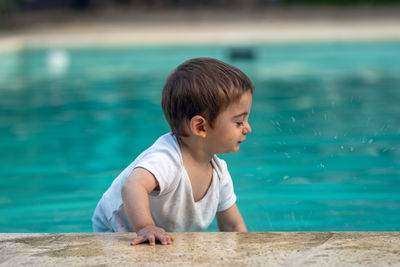 Cute smiling boy near swimming pool