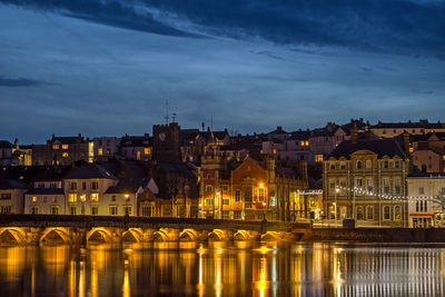 Illuminated buildings in city at waterfront