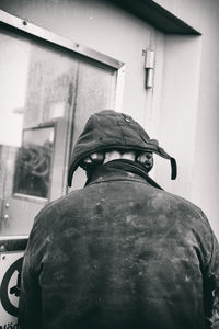 Rear view of man standing against building in city