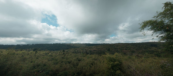 Scenic view of field against cloudy sky