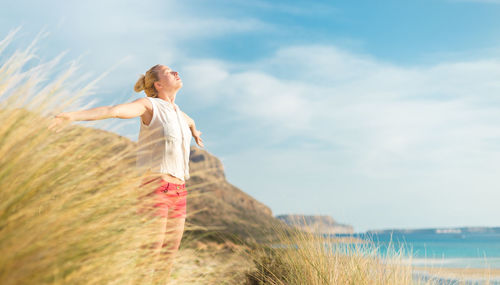 Woman standing on field against sky