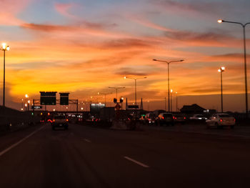 Traffic on road at sunset