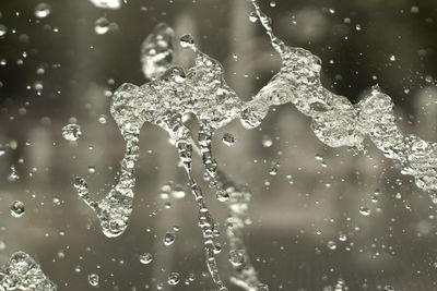 Close-up of raindrops splashing water