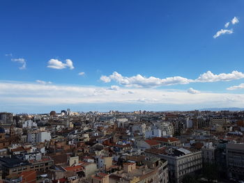 High angle shot of cityscape against blue sky