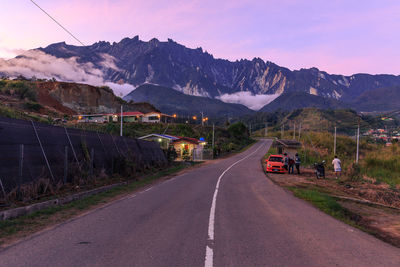 Road by mountain against sky