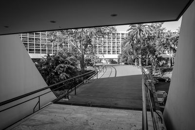 Empty footpath amidst buildings in city