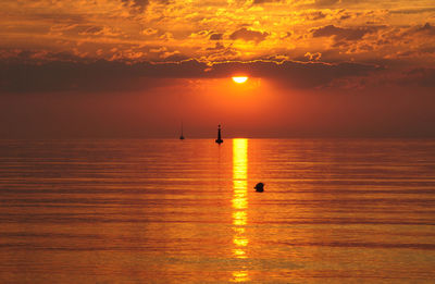 Scenic view of seascape against cloudy sky at dusk