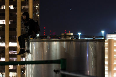 Man standing on illuminated table at night