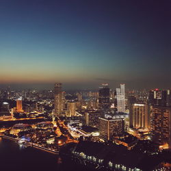 Illuminated cityscape against clear sky at night