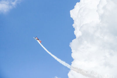Low angle view of airplane flying against sky
