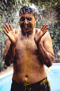 Close-up of man splashing water in swimming pool