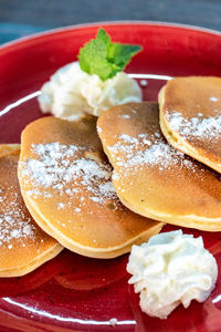 A image of freshly made american style pancakes severed with fresh fruit and cream