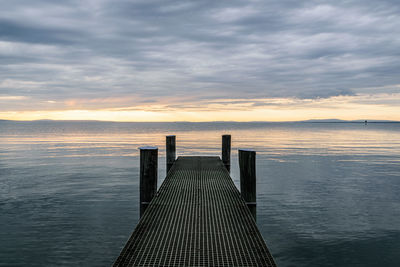 Pier over sea against sky during sunset