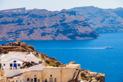 Yacht in the sea and beautiful cozy traditional white cave house on santorini island. santorini