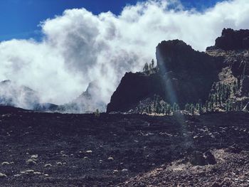 Panoramic view of smoke emitting from land against sky