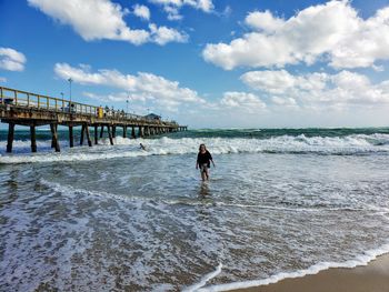 Woman standing on beach against sky